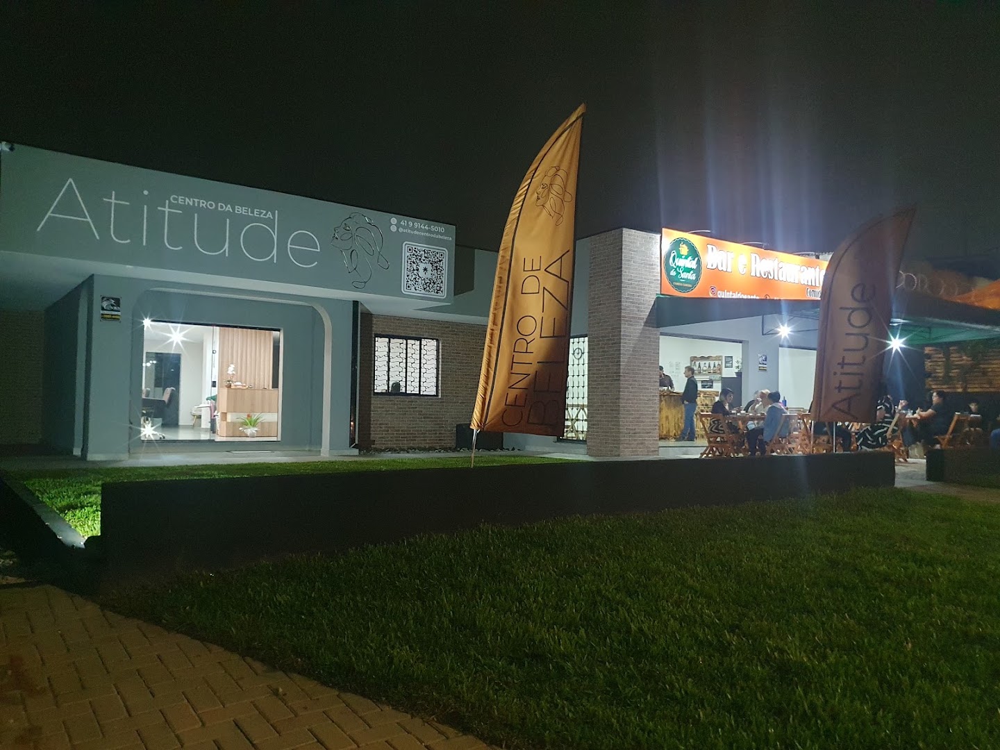 Fachada da Atitude Centro da Beleza iluminada à noite, em Santa Cândida